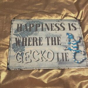 Metal sign- Happiness is where the gecko lie. Has blue background, teal gecko